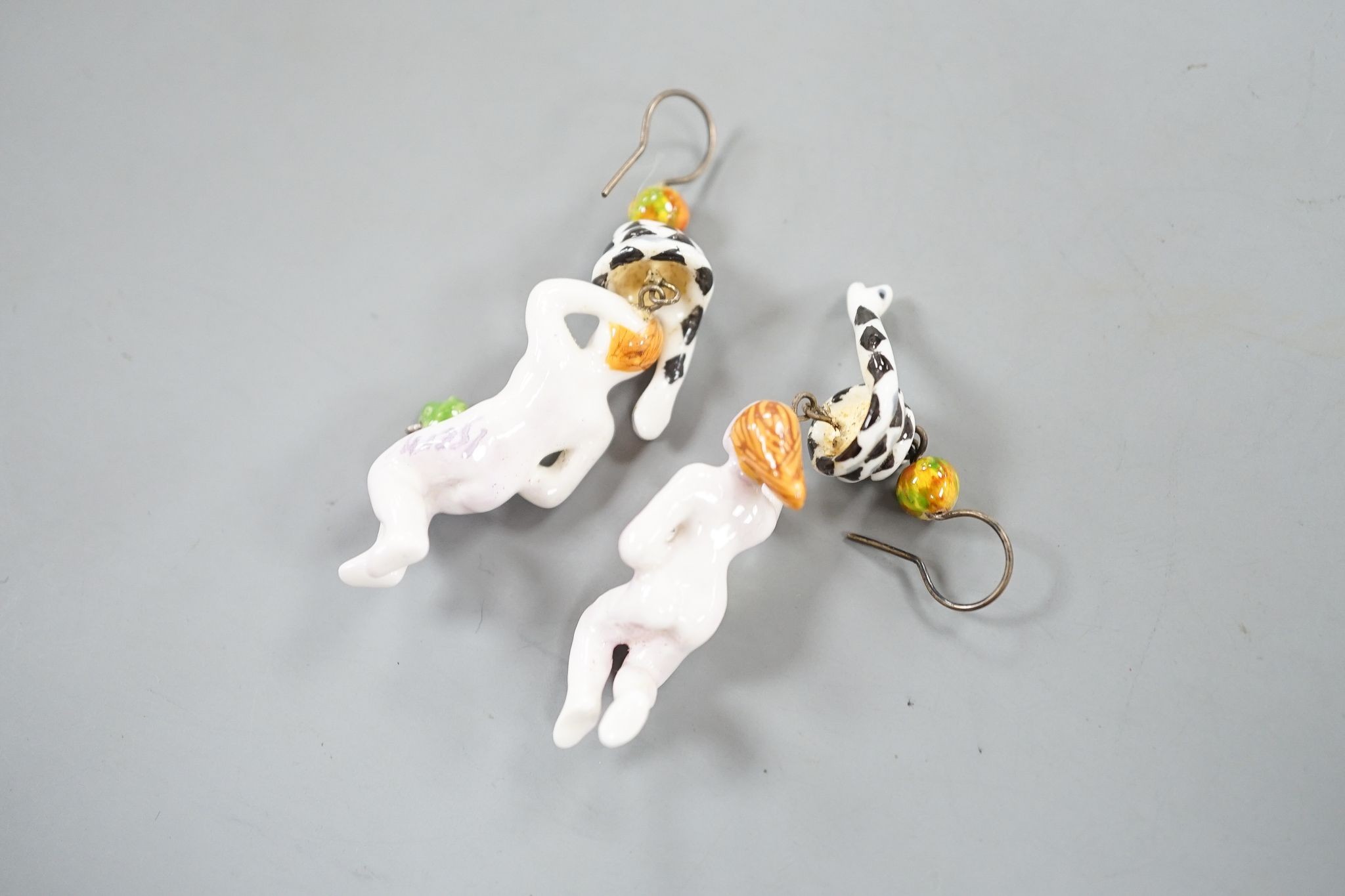 A pair of painted porcelain 'Adam & Eve with serpent' drop earrings, 62mm